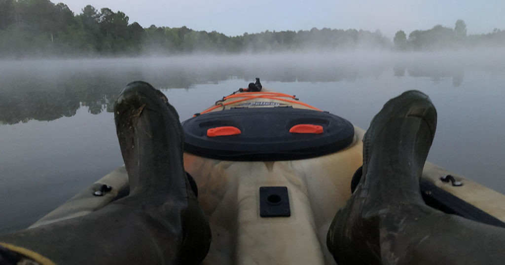 Pelican hunting kayak on a foggy lake