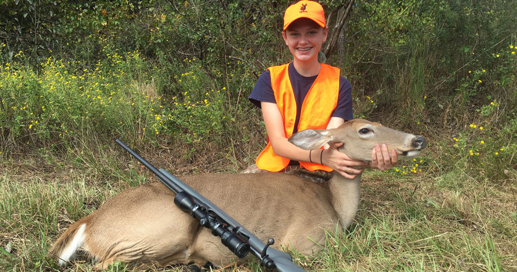 Photo of a female youth with a doe taken on a youth hunt.