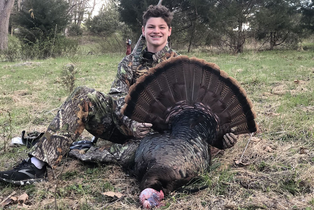 Photo of a youth hunter with a big gobbler taken during a youth turkey hunt.